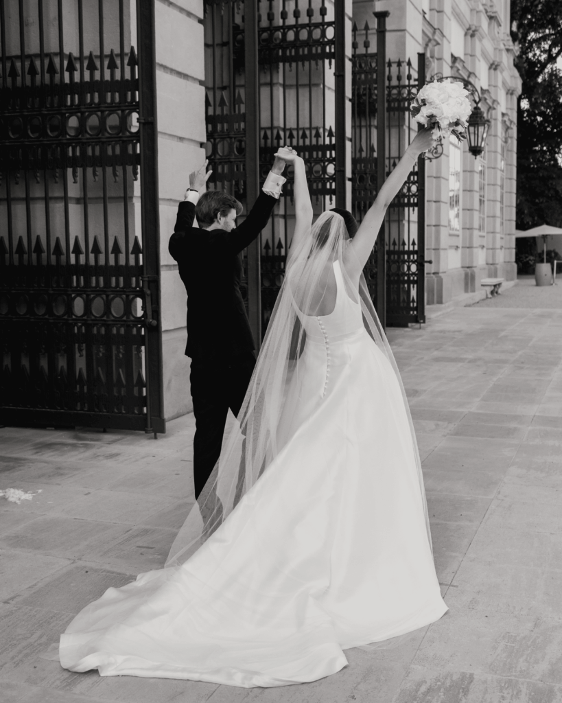 Bride and groom celebrating their wedding in front of a historic building