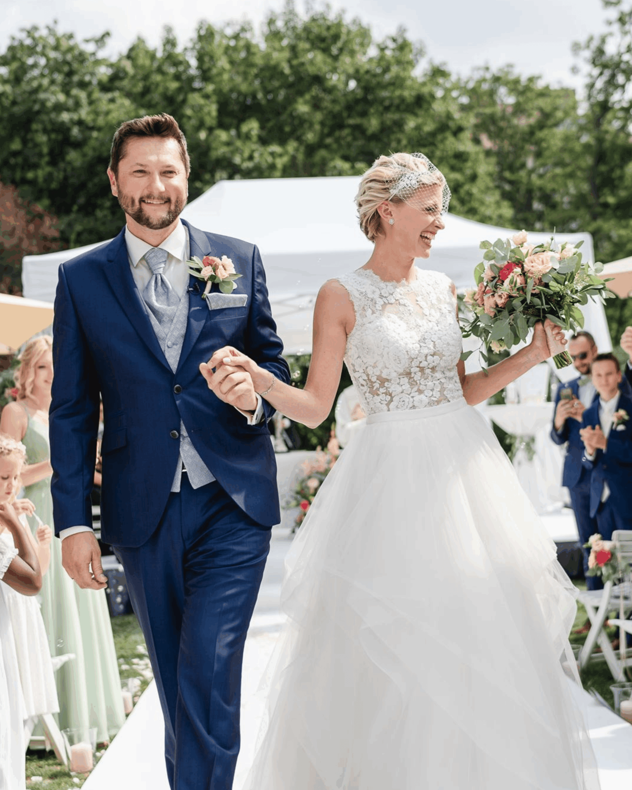 Bride and groom leaving the ceremony hand in hand under the applause of their guests