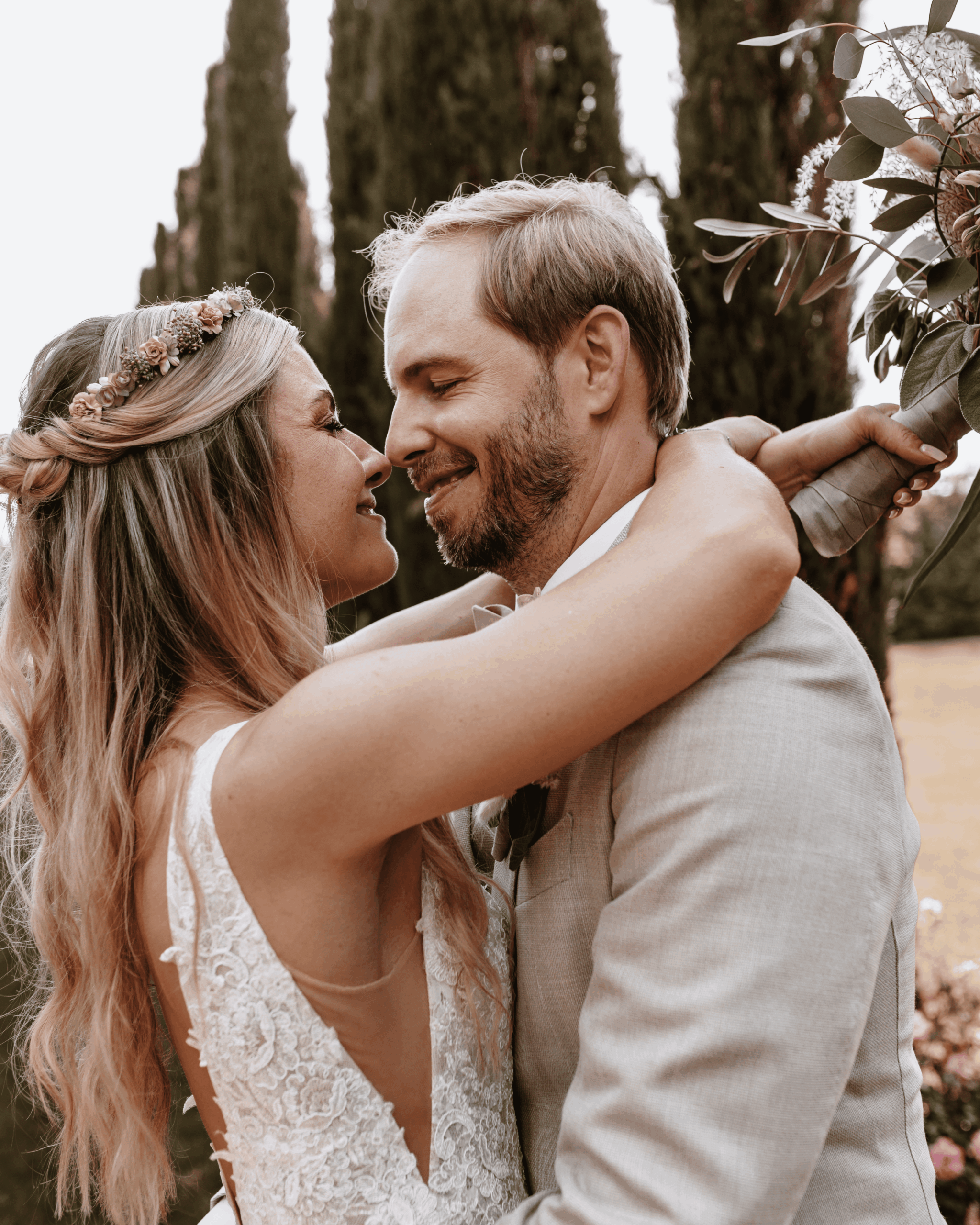 Bride and groom embrace in the garden, warm wedding portrait in natural light